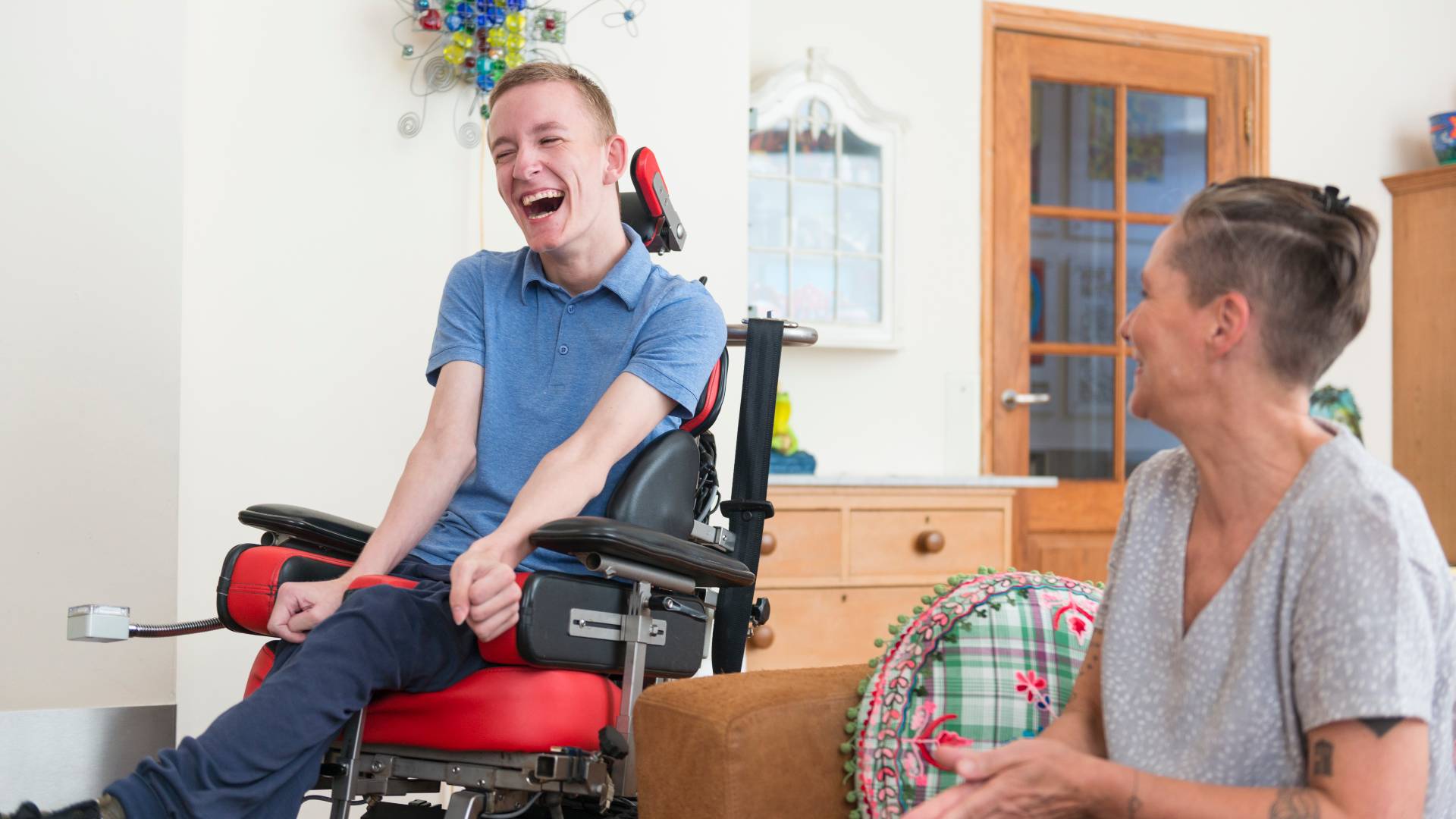 Happy young ALS patient with his mom