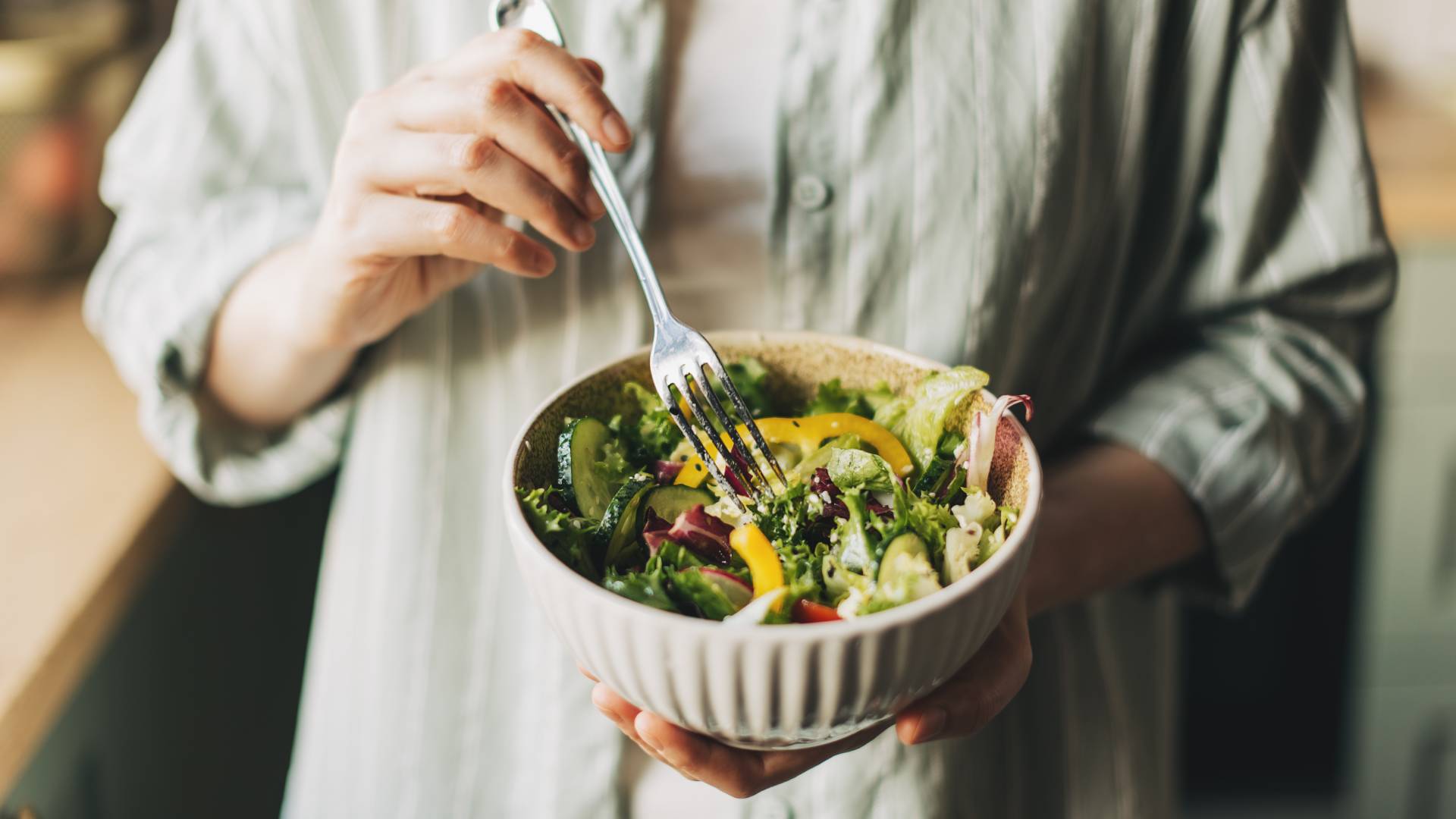 Woman holding bowl with heart-healthy vegan food